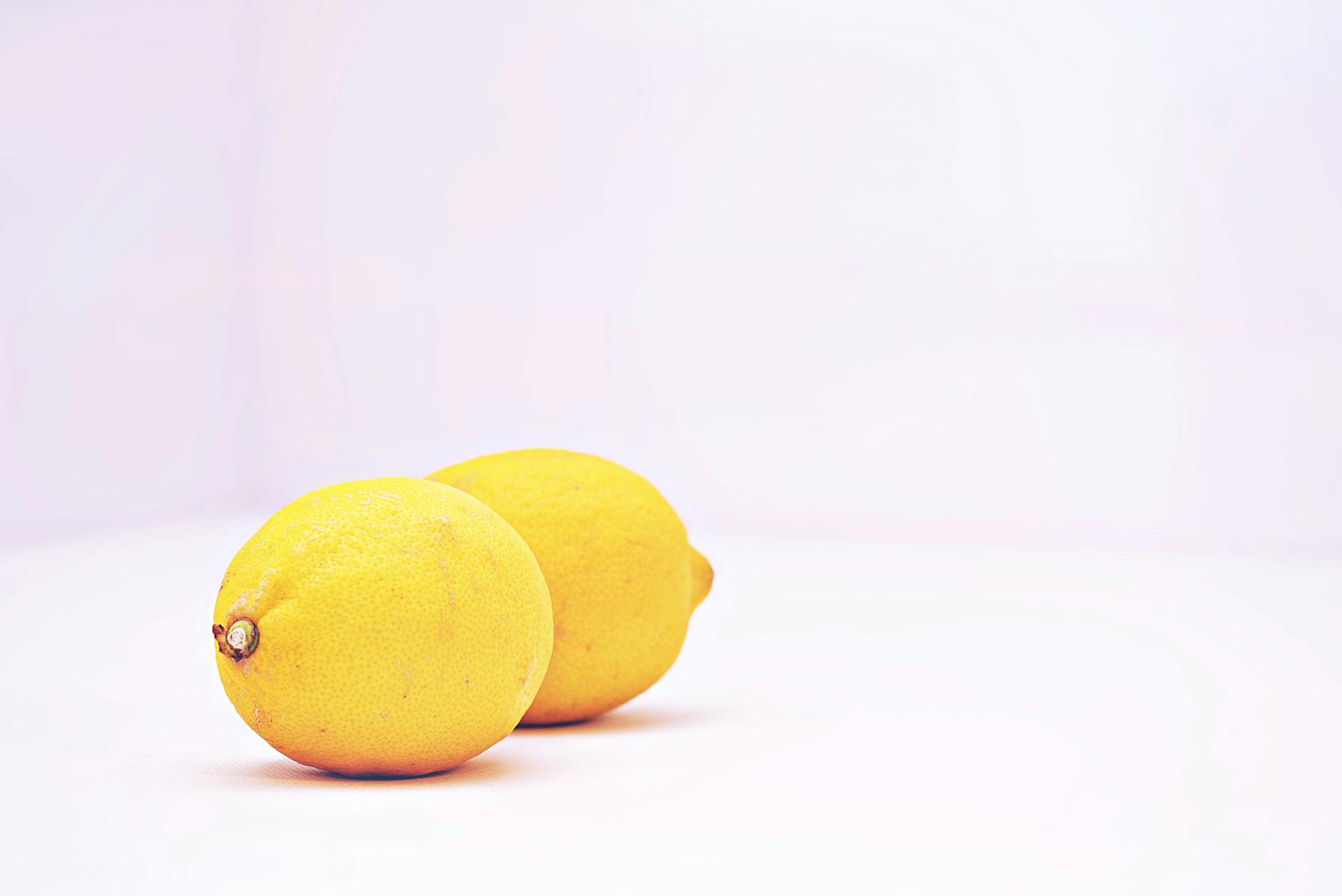 Two bright yellow lemons on a clean white background, representing the Hello Nancy lemon vibrator design