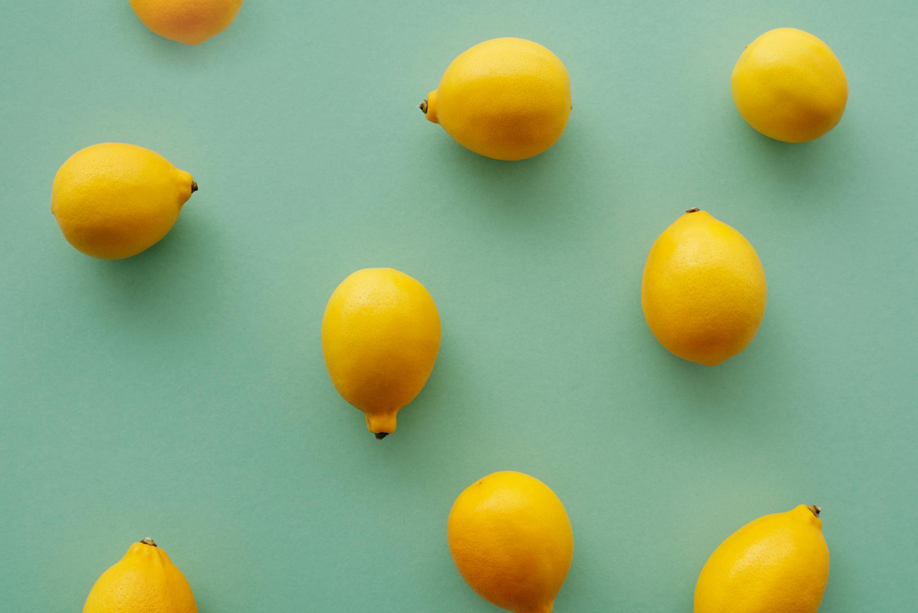 Bright yellow lemons arranged on a pastel green background, symbolizing fresh approaches to pleasure and intimacy