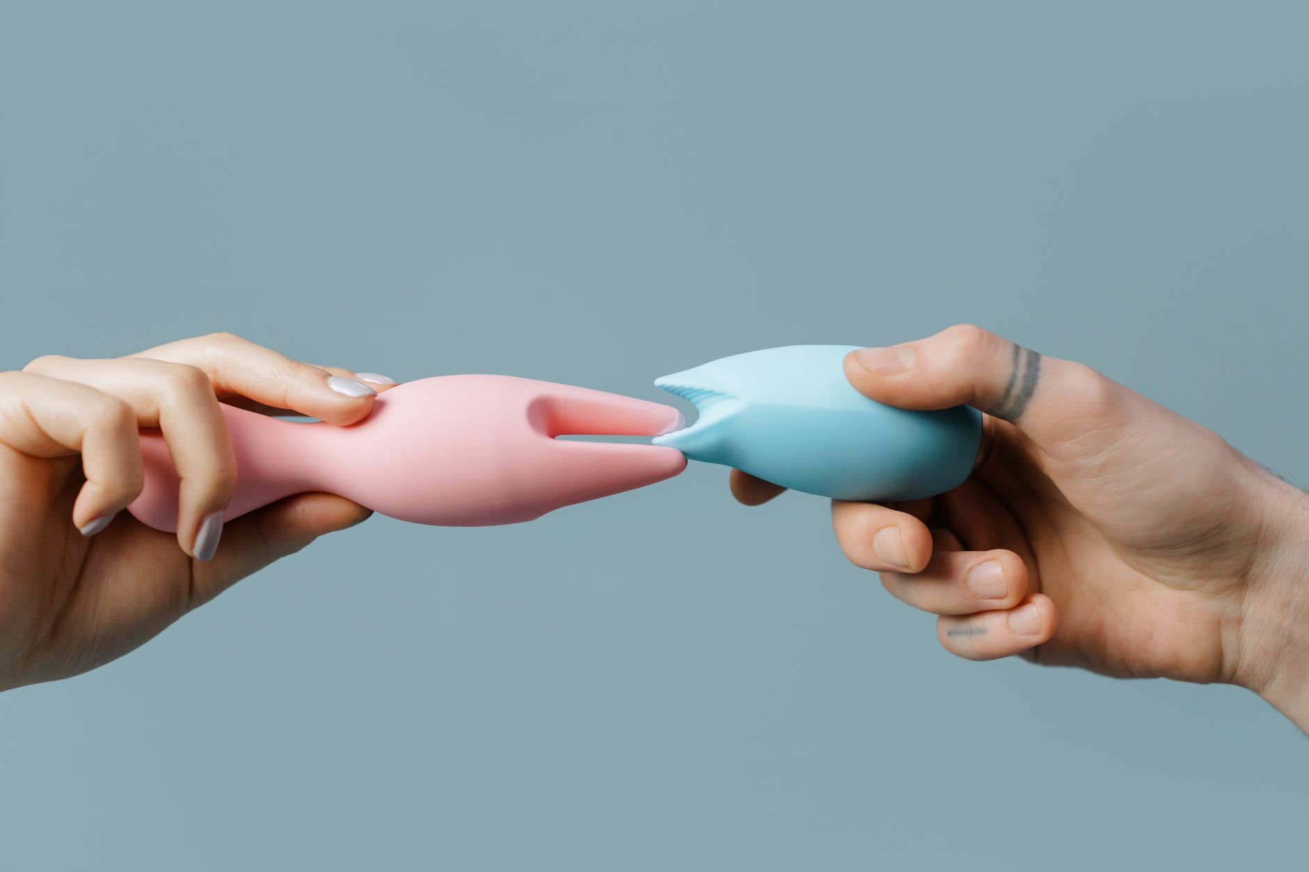 Hand holding a vibrator against a minimalist backdrop, symbolizing intentional pleasure after recovery