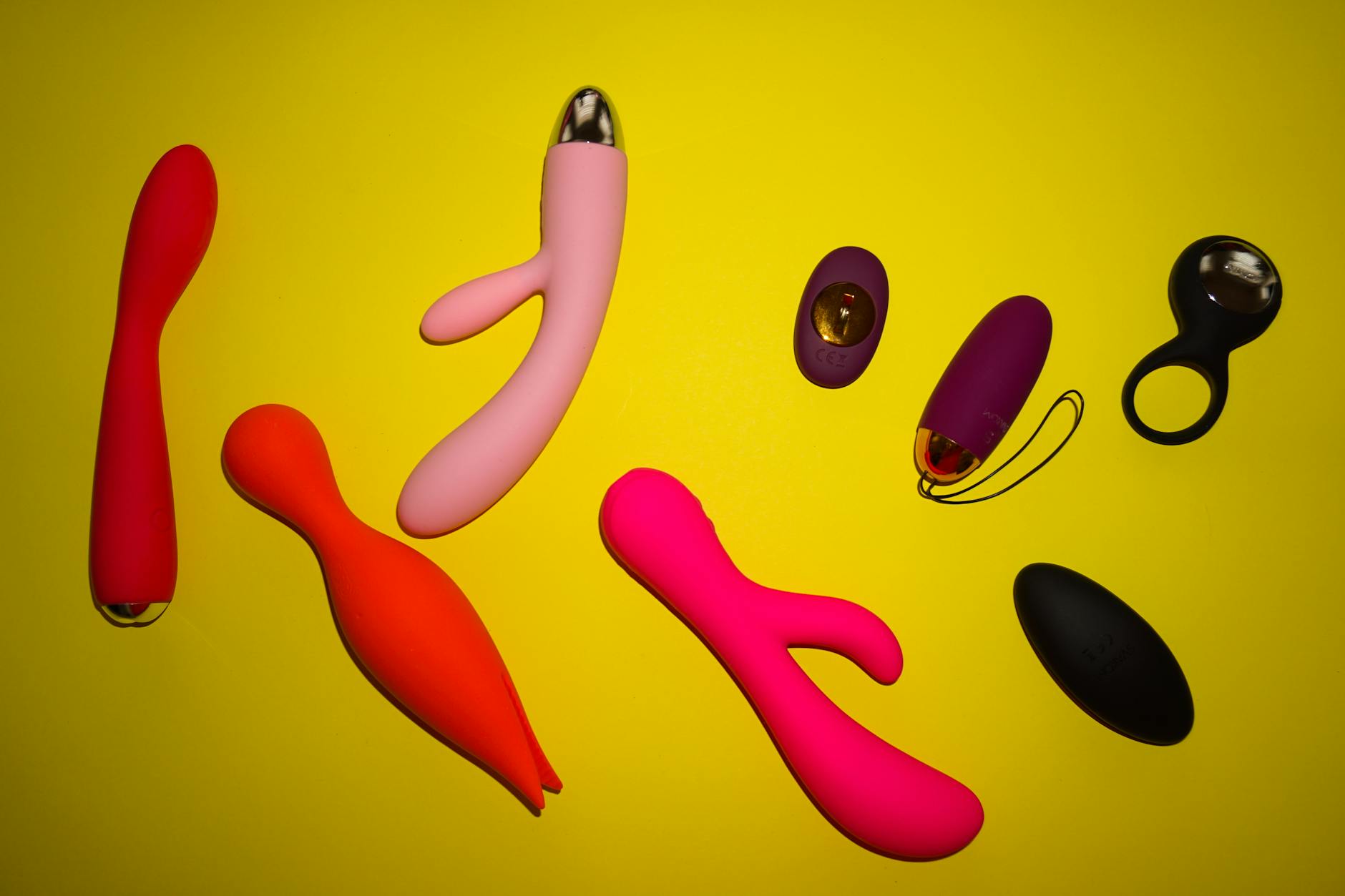 Vibrant arrangement of colorful lemon vibrators and wellness toys on a bright yellow surface